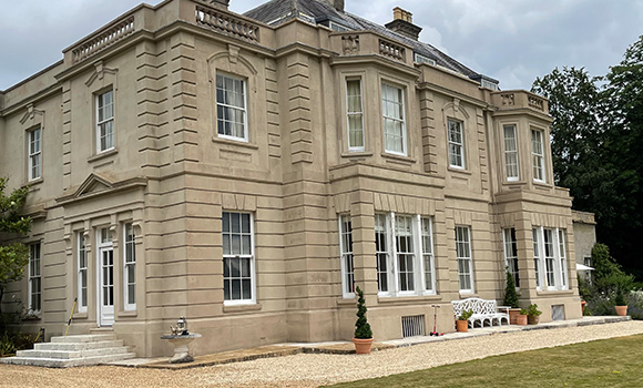 historic building with two service vans parked outside surrounded by grass beautiful architecture four service vehicles